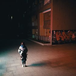 Full length of woman standing on footpath at night