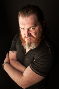 Portrait of man wearing hat against black background