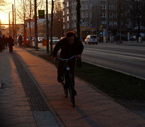 Man sitting on street in city