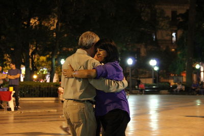 Couple kissing in city at night