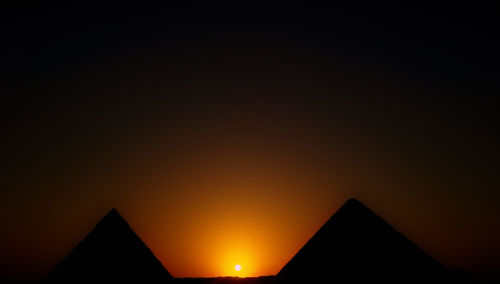 Silhouette buildings against clear sky during sunset