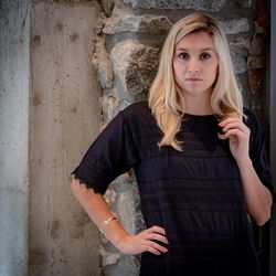 Portrait of a beautiful young woman standing against wall