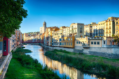 Canal amidst cityscape against clear sky