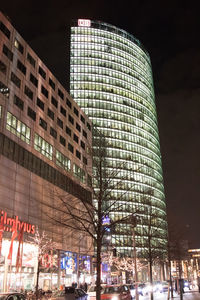 Low angle view of illuminated buildings against sky at night