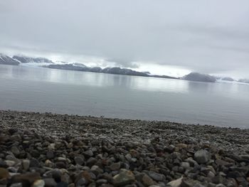 Scenic view of lake against cloudy sky