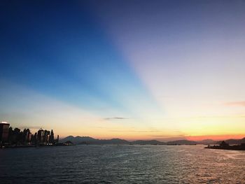 Scenic view of sea and buildings against sky during sunset