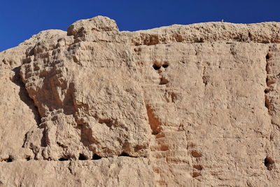 Low angle view of rocks against clear sky