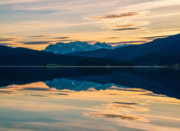 Scenic view of dramatic sky over lake during sunset