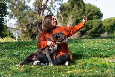 Woman taking selfie with dog at park