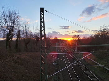 Chainlink fence on landscape at sunset