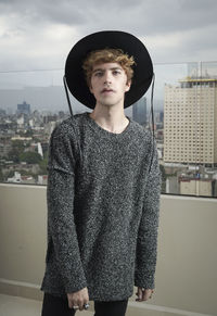 Portrait of teenage girl standing against cityscape