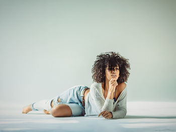 Young woman lying on floor against wall