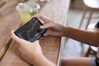 Cropped hands of woman using mobile phone