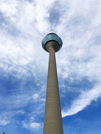 Low angle view of communications tower against cloudy sky