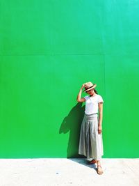 Full length of woman standing against wall