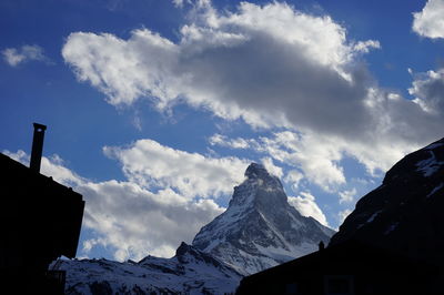 Low angle view of snowcapped mountains against sky