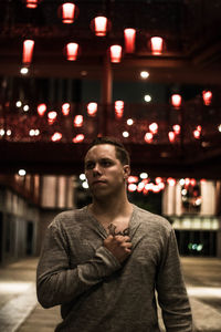 Portrait of young man standing at night