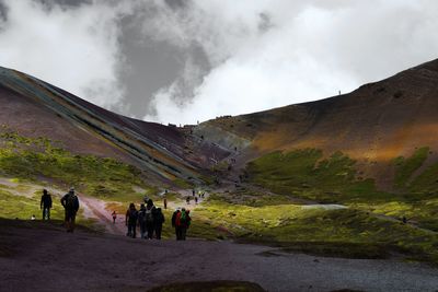 People on mountain against sky