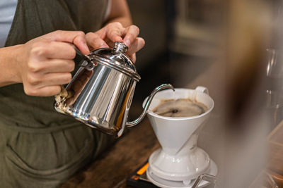 Midsection of man pouring coffee in cup