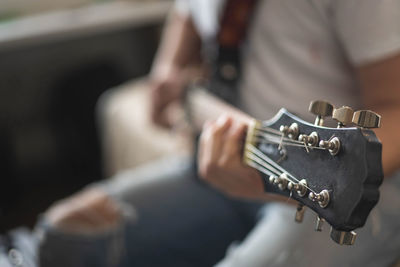 Midsection of man playing guitar