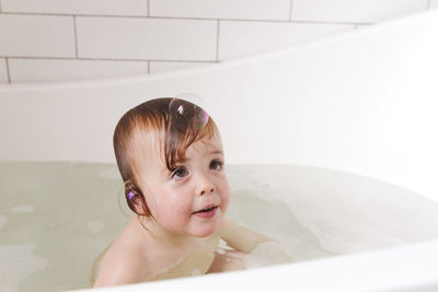 Adorable bath baby boy with soap suds on hair