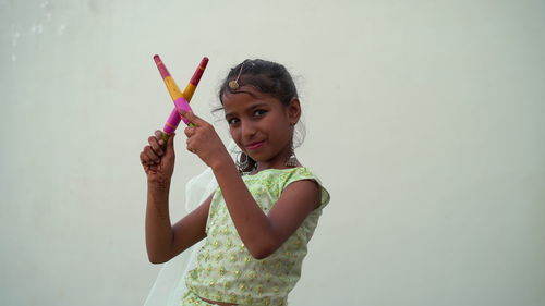Indian beautiful little girl with garba sticks or dandiya on indian festival navratri.