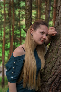 Portrait of young woman in tree trunk