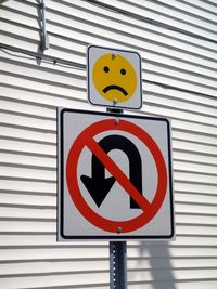 Close-up of road sign against brick wall