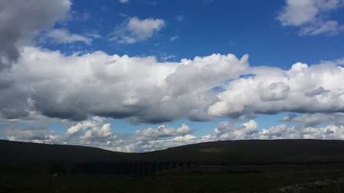 Scenic view of mountains against cloudy sky