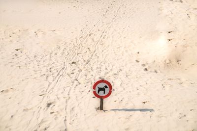 High angle view of road sign on sand at beach