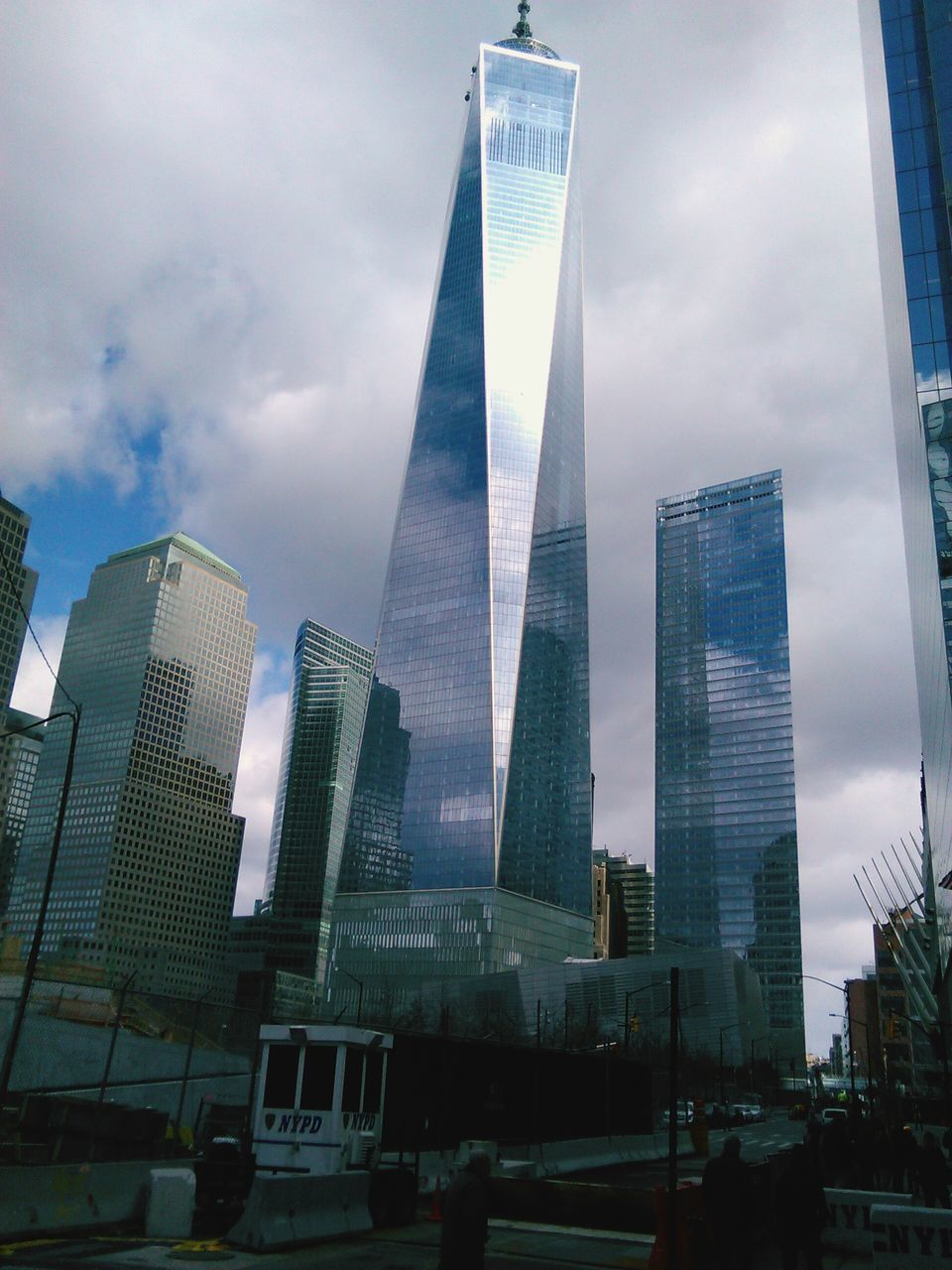 skyscraper, building exterior, city, architecture, modern, built structure, tall - high, office building, tower, sky, low angle view, cloud - sky, financial district, glass - material, capital cities, city life, tall, urban skyline, building, cityscape