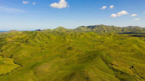  green hills and mountains with tropical vegetation and blue sky with clouds. 