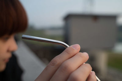 Close-up portrait of woman holding hands against blurred background