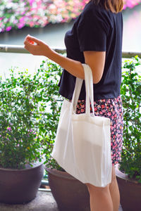 Midsection of woman standing by potted plant
