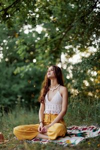 Portrait of young woman sitting at park