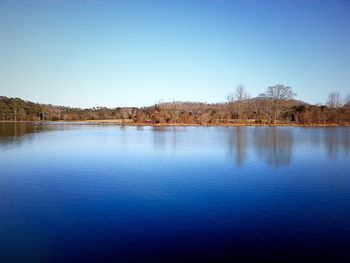 Scenic view of calm lake against clear blue sky