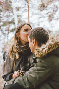 Woman kissing boyfriend in park