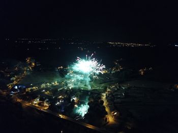 High angle view of illuminated cityscape against sky at night