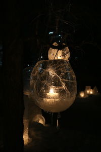Close-up of illuminated crystal ball hanging at night
