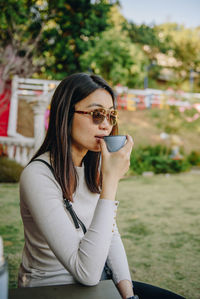 Young woman having drink at park