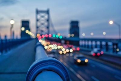 Illuminated vehicles on benjamin franklin bridge against sky during sunset