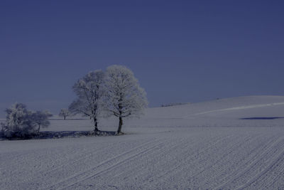 Scenic view of snow covered landscape against clear blue sky