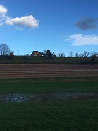 Scenic view of grassy field against cloudy sky