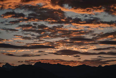 Scenic view of silhouette mountains against dramatic sky