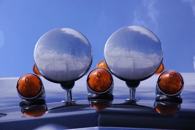 Low angle view of lights on semi-truck hood against sky