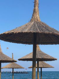 Gazebo by sea against clear blue sky