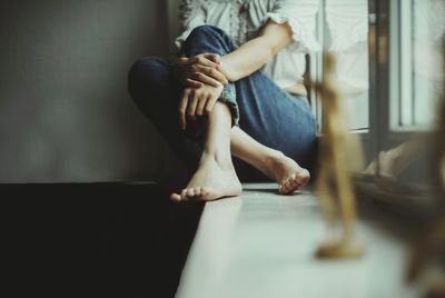 Low section of woman sitting at home