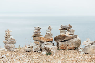 Stack of stones on beach against sky