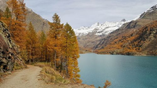 Scenic view of lake by mountains against sky during winter