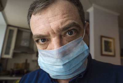 Adult man in medical mask at home